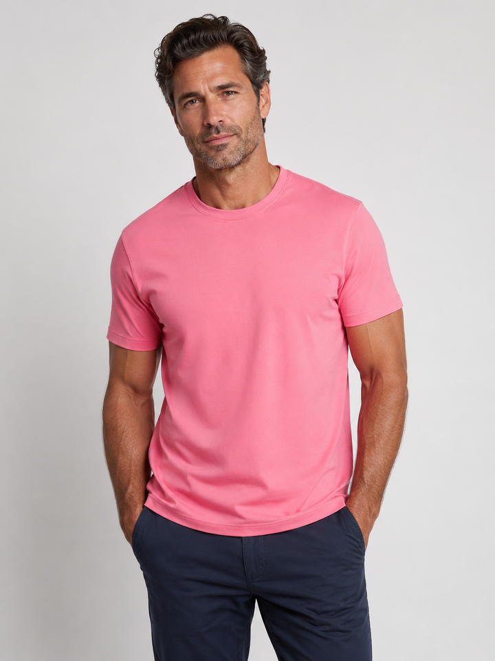 Man wearing a Cinqo Tee shirt in Slate Rose and navy pants on a light gray background