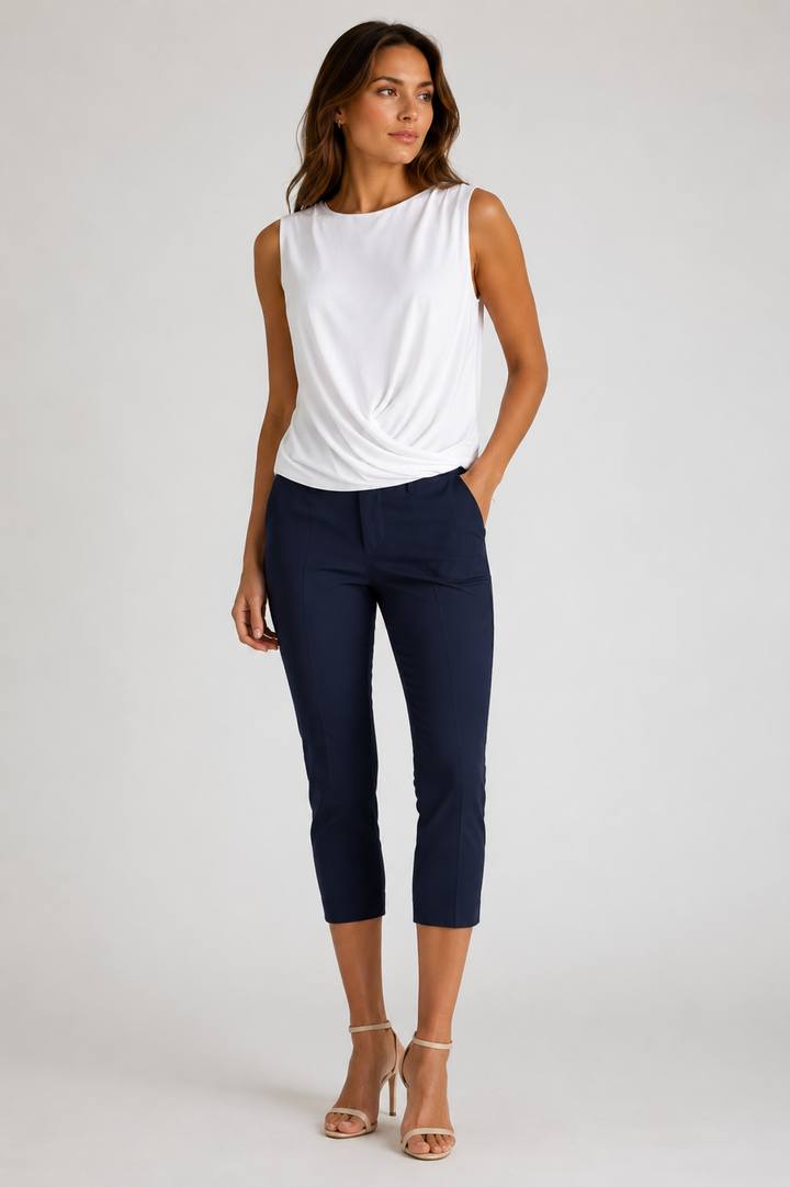 Woman wearing a white Boss Crew sleeveless top and navyEasy Street pants on a light gray background