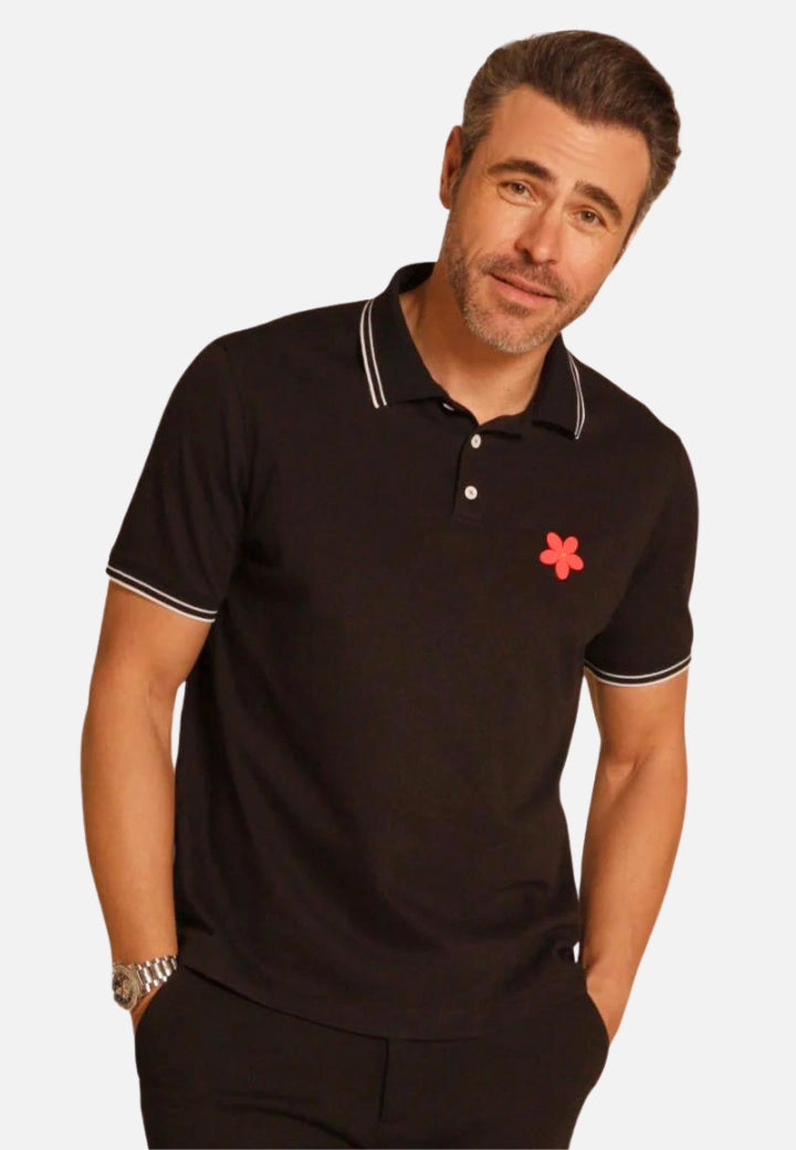 Made in Thailand, this Buki "happy" polo shirt features a "happy" flower motif on the chest. In Black.
