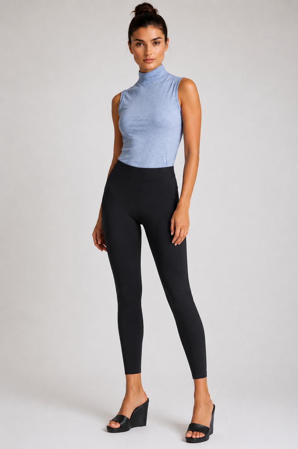 Woman wearing sleeveless Seamless top and black Rise and Shine leggings on a white background