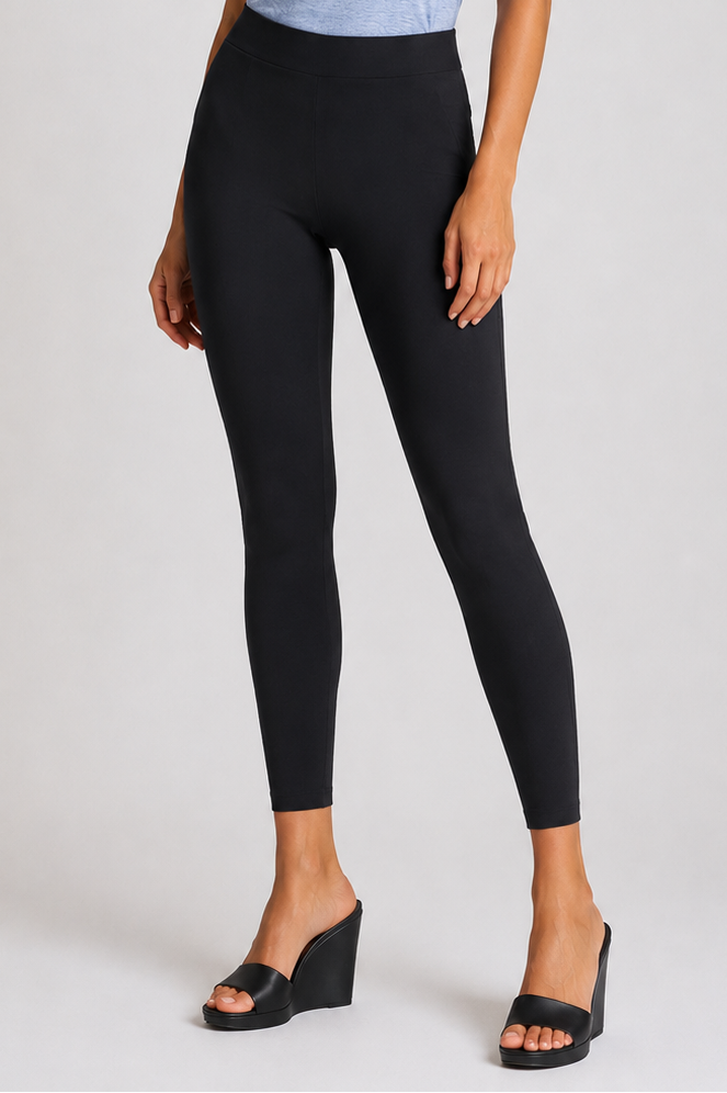 Woman wearing aseamless sleeveless top and black rise and shine leggings on a white background