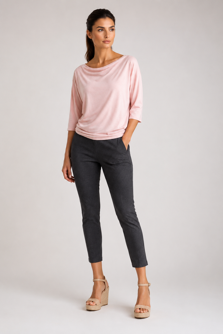 Woman wearing a pink Bon Voyage top and gray Unisexy pants on a white background